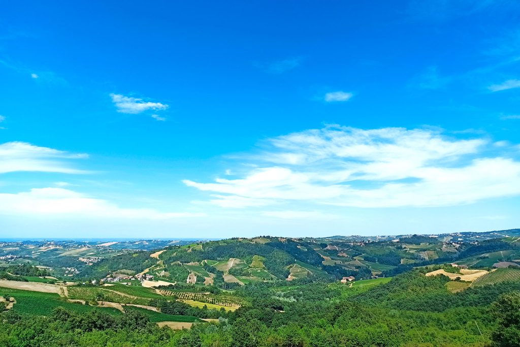 Paesaggio collinare italiano osservato da un emigrante clandestino in Italia, simbolo di attesa, distanza e speranza di una nuova vita